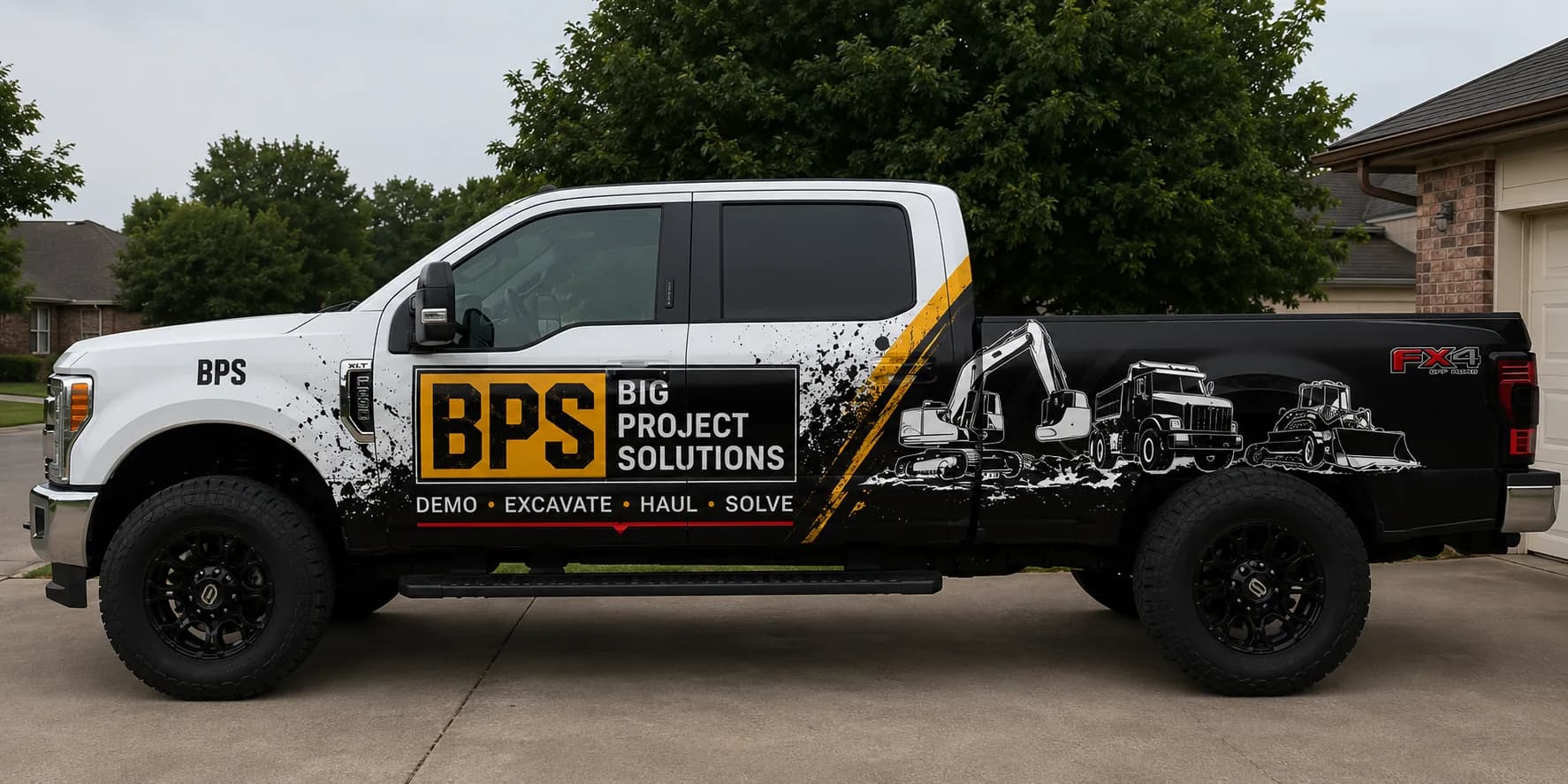 The Big Project Solutions truck — a white and black crew-cab pickup wrapped with the BPS mark, the line DEMO · EXCAVATE · HAUL · SOLVE, and silhouettes of an excavator, dump truck and loader down the bed.